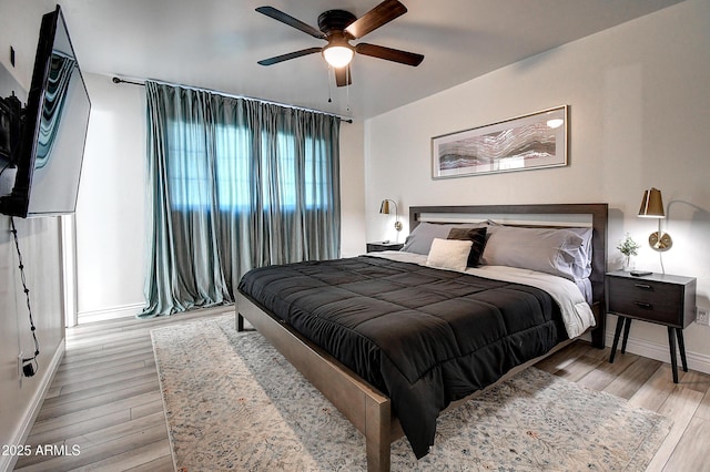 bedroom featuring light wood-style floors, ceiling fan, and baseboards