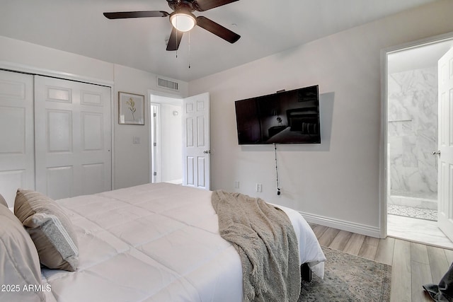 bedroom featuring ensuite bathroom, ceiling fan, wood finished floors, visible vents, and a closet