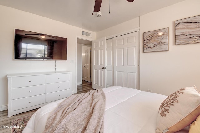 bedroom with a ceiling fan, a closet, visible vents, and wood finished floors