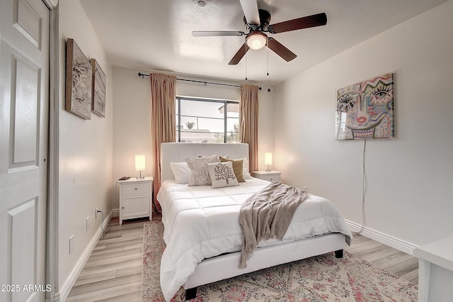 bedroom with light wood-type flooring, ceiling fan, and baseboards