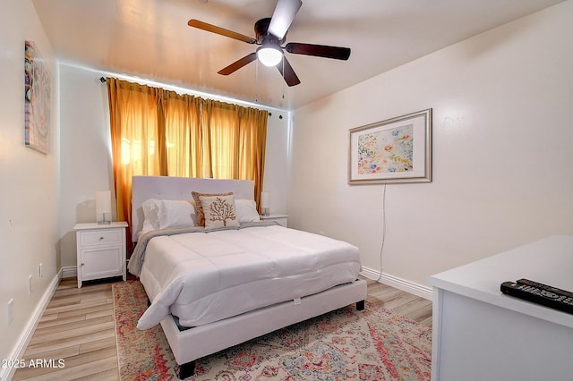 bedroom featuring light wood-style flooring, baseboards, and ceiling fan