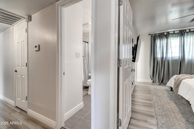 bedroom with light wood-type flooring, visible vents, and baseboards