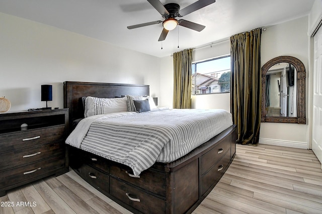 bedroom with a ceiling fan, light wood-type flooring, and baseboards