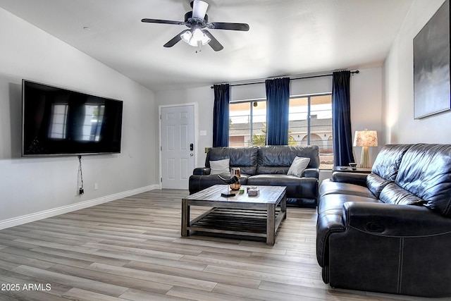 living area featuring light wood-type flooring, baseboards, a ceiling fan, and lofted ceiling