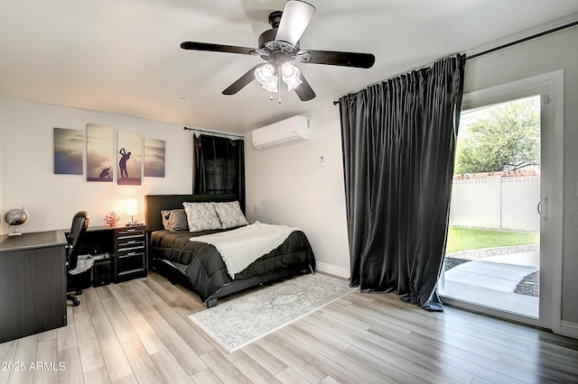 bedroom featuring light wood-type flooring, access to outside, baseboards, and a wall mounted AC