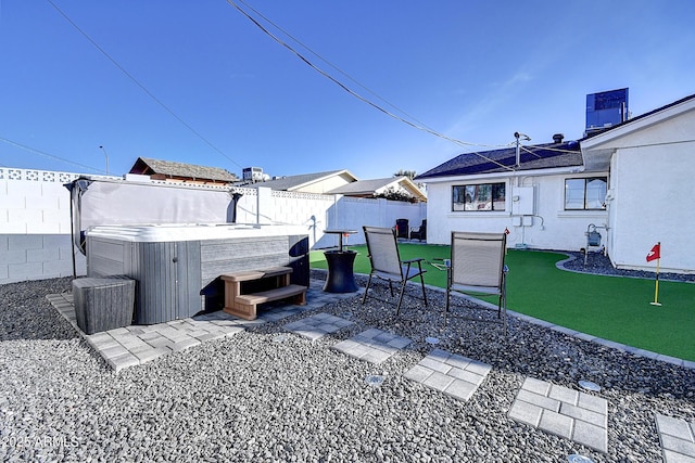 view of yard featuring a hot tub, a fenced backyard, and a patio