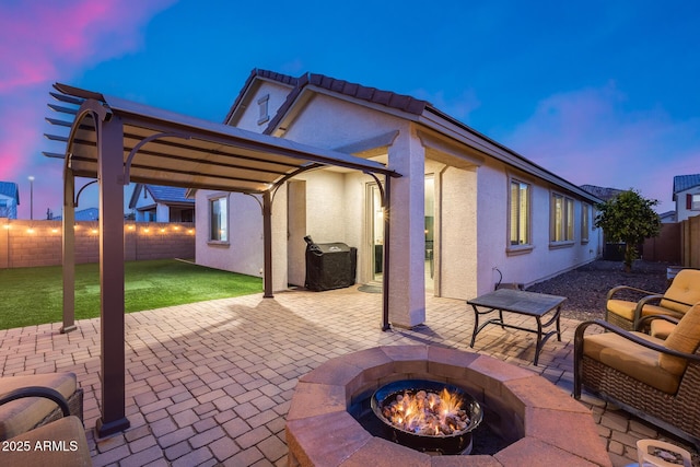 patio terrace at dusk featuring an outdoor fire pit