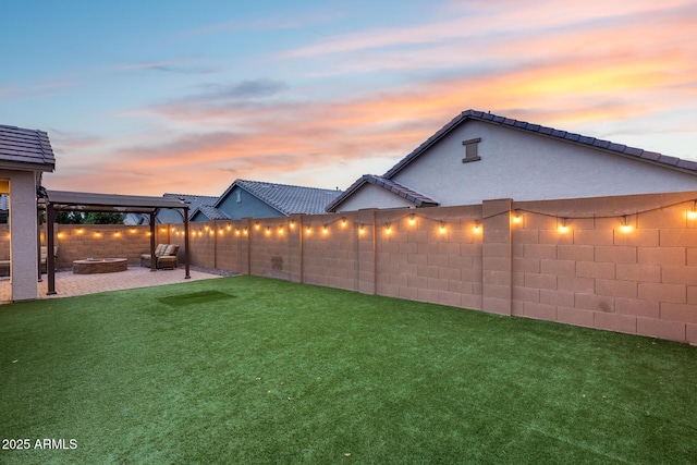 yard at dusk with a fire pit and a patio area