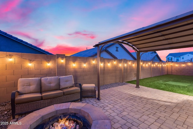 patio terrace at dusk featuring an outdoor living space with a fire pit