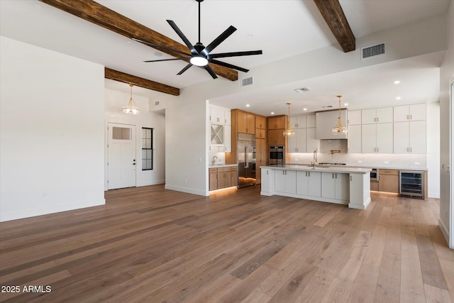3323 N 81st St, Mesa, AZ 85207 - kitchen with wine cooler, appliances with stainless steel finishes, beam ceiling, decorative backsplash, and open floor plan