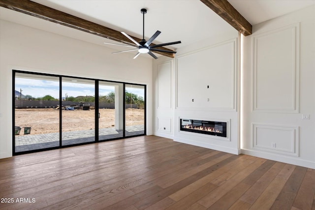 3323 N 81st St, Mesa, AZ 85207 - unfurnished living room featuring beam ceiling, a glass covered fireplace, ceiling fan, and hardwood / wood-style floors