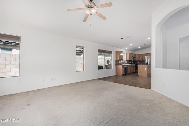 2268 S 162nd Ln, Goodyear, AZ 85338 - unfurnished living room featuring dark carpet, a sink, ceiling fan, arched walkways, and vaulted ceiling