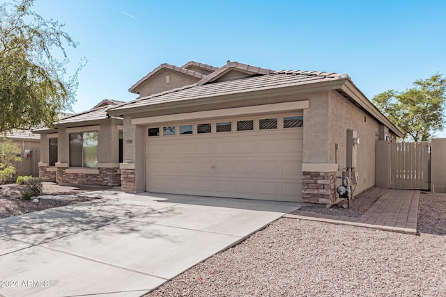 2268 S 162nd Ln, Goodyear, AZ 85338 - view of front facade featuring concrete driveway, stucco siding, an attached garage, and stone siding