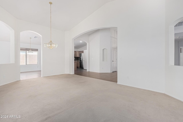 2268 S 162nd Ln, Goodyear, AZ 85338 - unfurnished room with baseboards, high vaulted ceiling, a notable chandelier, and carpet floors