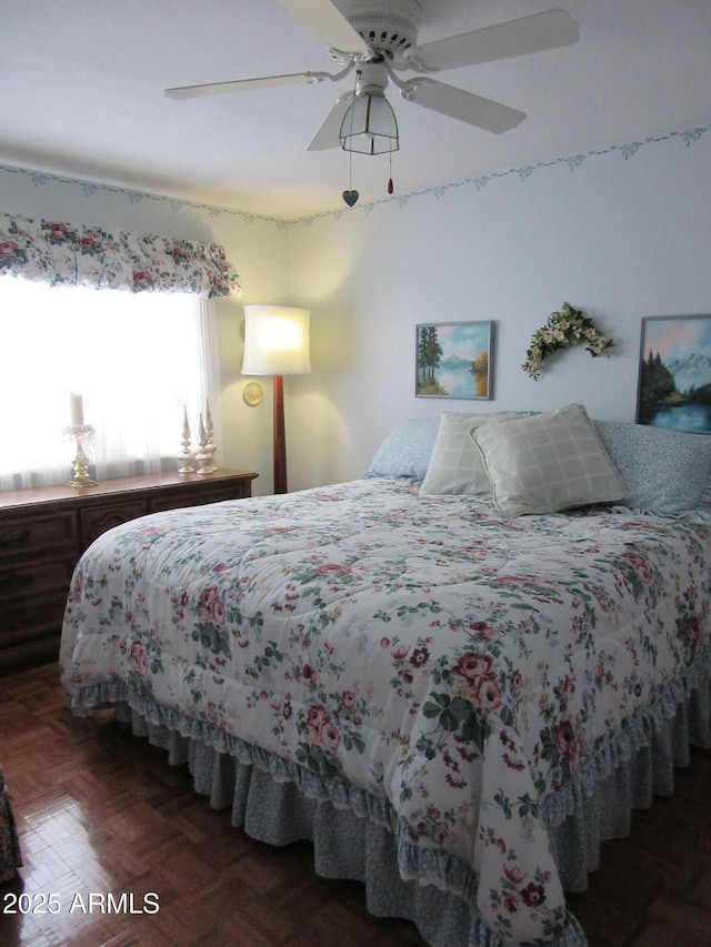 bedroom with dark parquet floors and ceiling fan