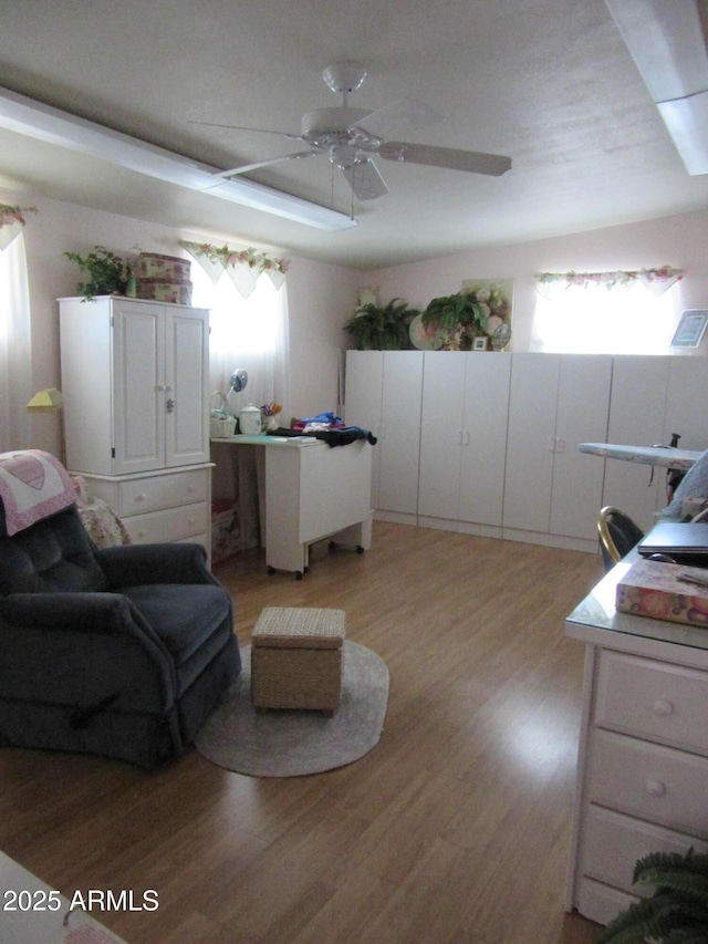 living room featuring ceiling fan, plenty of natural light, and light hardwood / wood-style floors