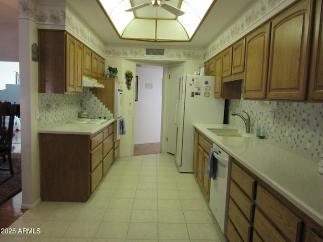 kitchen featuring sink, white appliances, light tile patterned floors, ceiling fan, and backsplash