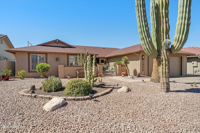 ranch-style home with an attached garage, fence, concrete driveway, a gate, and stucco siding