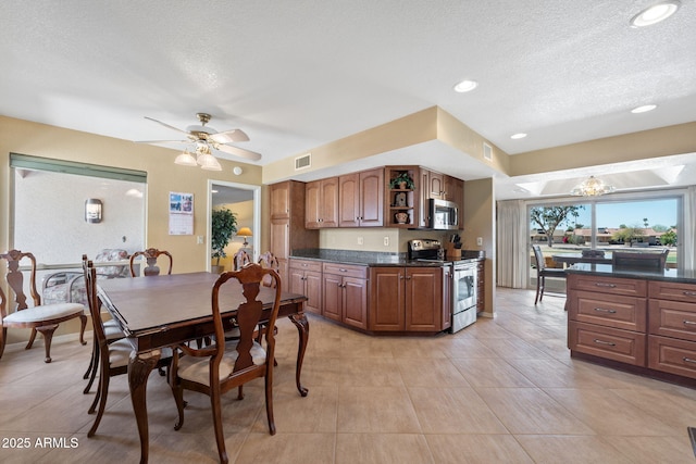 kitchen featuring stainless steel appliances, dark countertops, visible vents, and open shelves