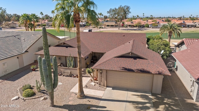 view of front of property featuring driveway, an attached garage, and a residential view