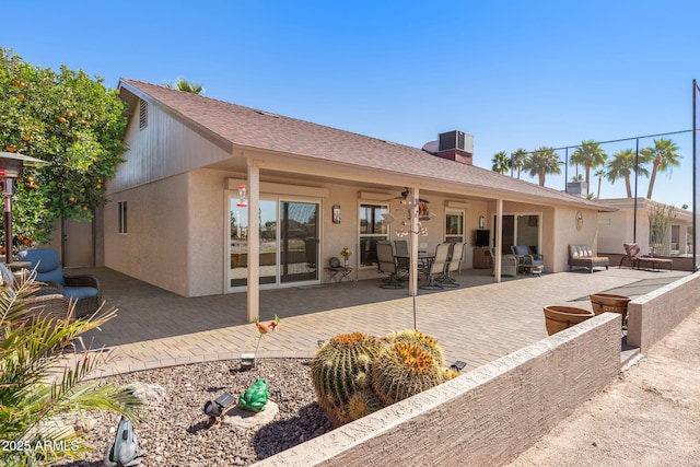 rear view of property with a patio area, a shingled roof, and stucco siding