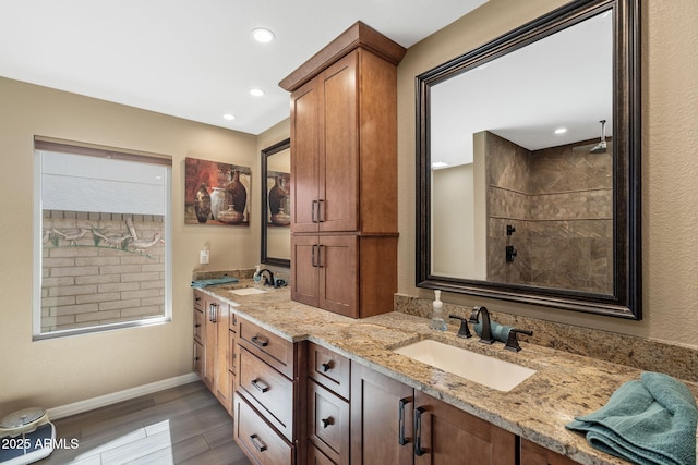 bathroom featuring wood finished floors, a sink, baseboards, and double vanity