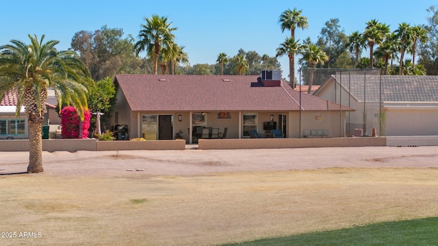 view of front of home featuring central AC, fence, and stucco siding