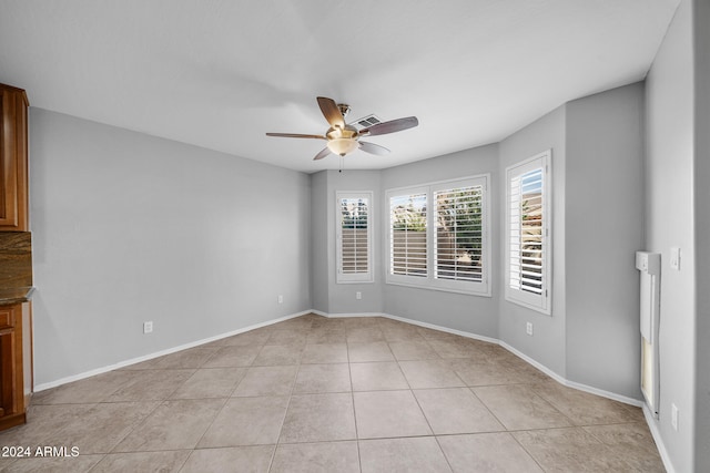 unfurnished room with ceiling fan and light tile patterned floors