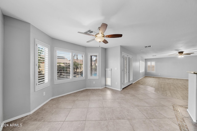 empty room featuring ceiling fan and light tile patterned floors