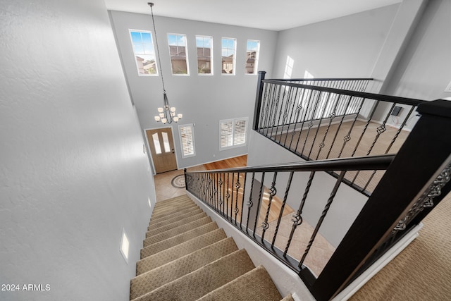 stairway with a notable chandelier