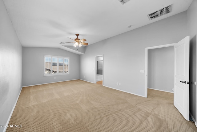 carpeted empty room featuring vaulted ceiling and ceiling fan