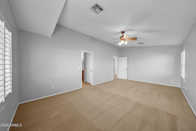 unfurnished bedroom with light colored carpet, multiple windows, and ceiling fan