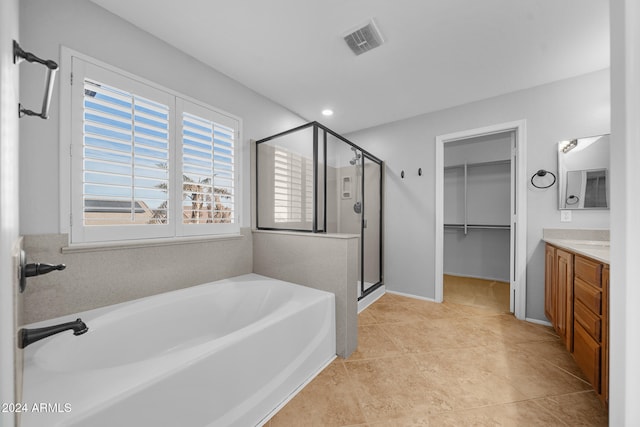 bathroom featuring plus walk in shower, vanity, and tile patterned floors