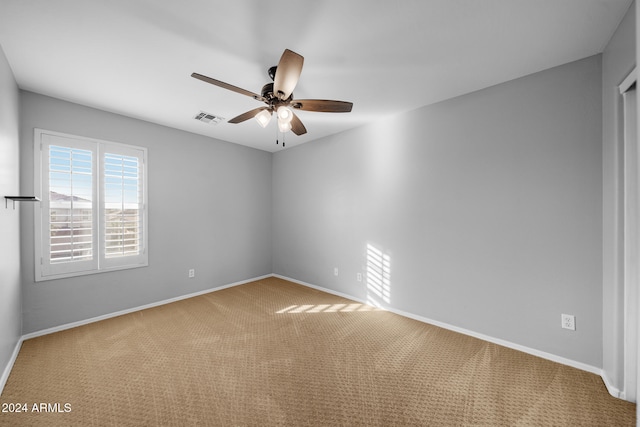 carpeted empty room featuring ceiling fan