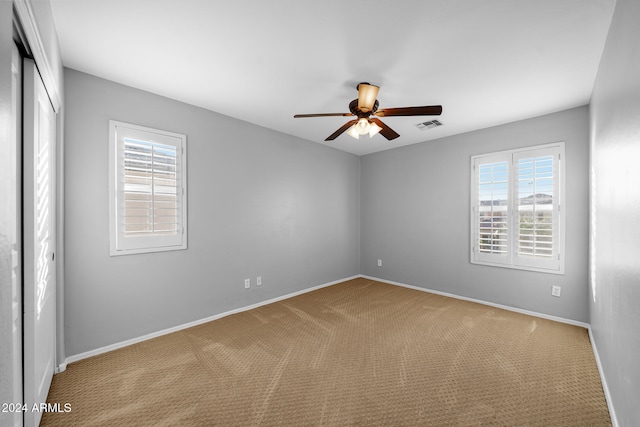 unfurnished room with light carpet and ceiling fan