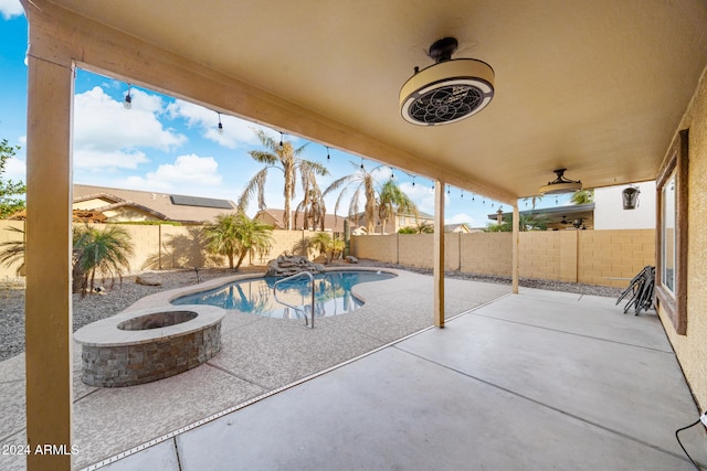 view of pool featuring ceiling fan, a patio area, and an outdoor fire pit