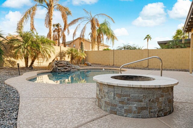 view of swimming pool featuring an in ground hot tub