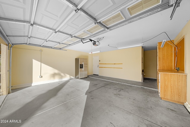 garage featuring stainless steel fridge and a garage door opener