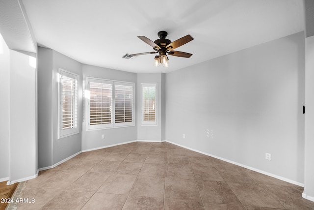 tiled spare room featuring ceiling fan