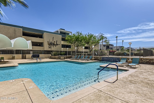 pool with a patio and fence