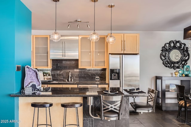 207 W Clarendon Ave Unit G18, Phoenix, AZ 85013 - kitchen with a sink, backsplash, stainless steel refrigerator with ice dispenser, a breakfast bar, and glass insert cabinets