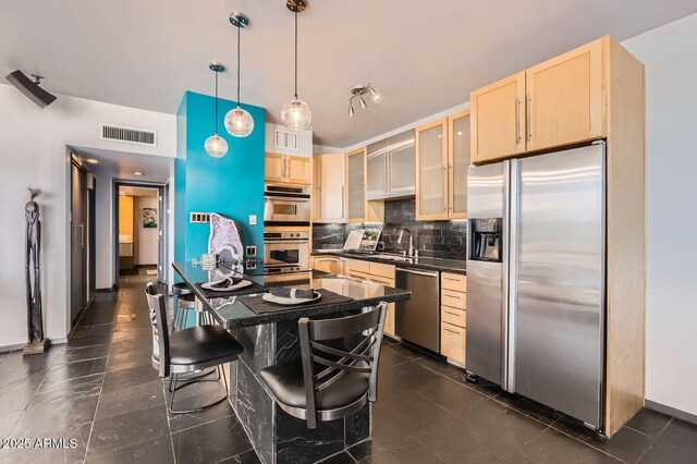207 W Clarendon Ave Unit G18, Phoenix, AZ 85013 - kitchen with appliances with stainless steel finishes, light brown cabinets, dark countertops, and decorative backsplash