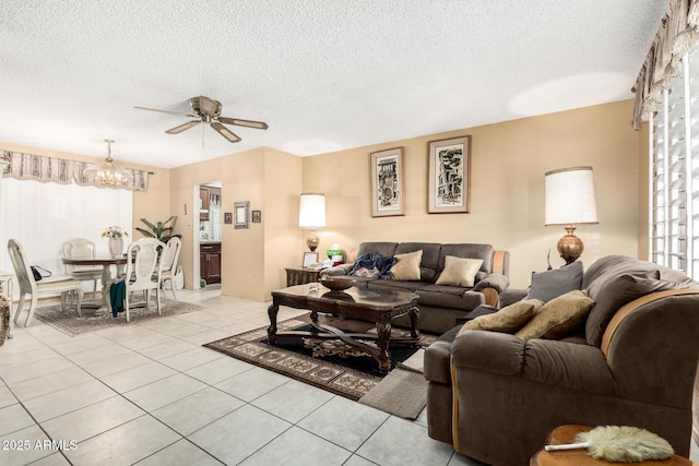 living area featuring ceiling fan with notable chandelier, a textured ceiling, and light tile patterned flooring