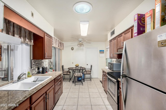 kitchen featuring light tile patterned floors, a sink, visible vents, appliances with stainless steel finishes, and decorative backsplash