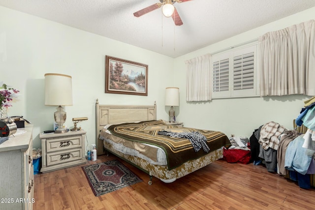 bedroom featuring ceiling fan, a textured ceiling, and wood finished floors