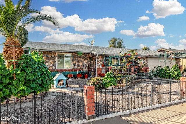 single story home with stone siding and a fenced front yard