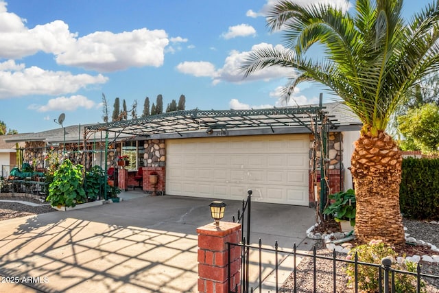 garage featuring concrete driveway and fence