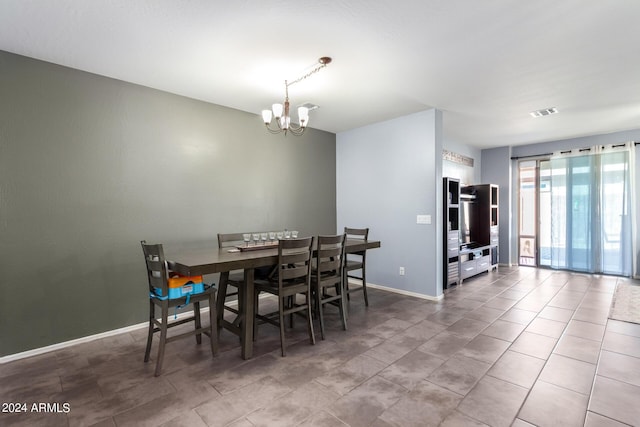 tiled dining space featuring an inviting chandelier