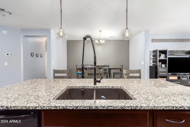 kitchen with sink, a kitchen island with sink, and hanging light fixtures