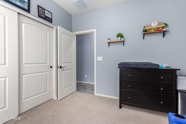 bedroom featuring light carpet and a closet